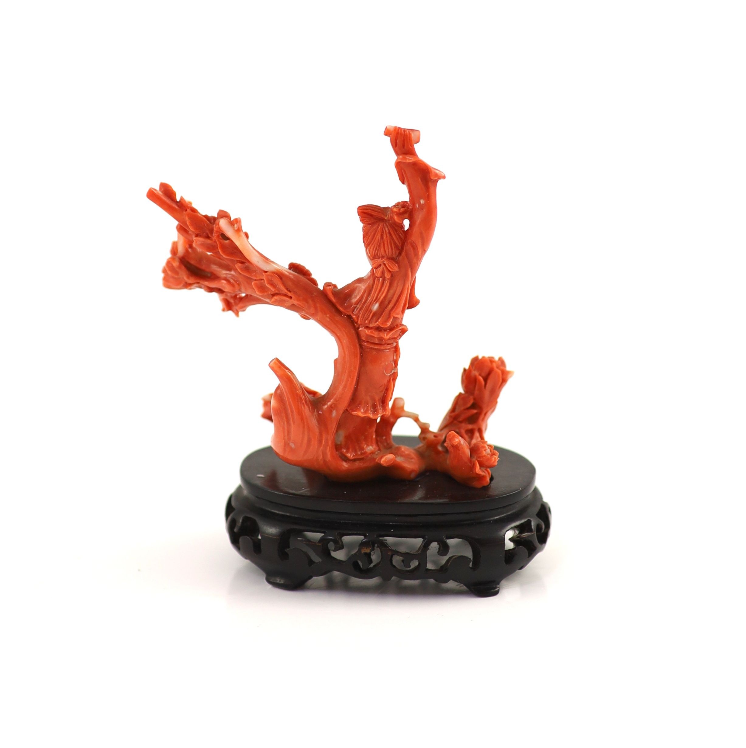 A Chinese coral figure of a lady amid flowering branches, mid 20th century 7.8 cm high, 9 cm wide, 60g, wood stand